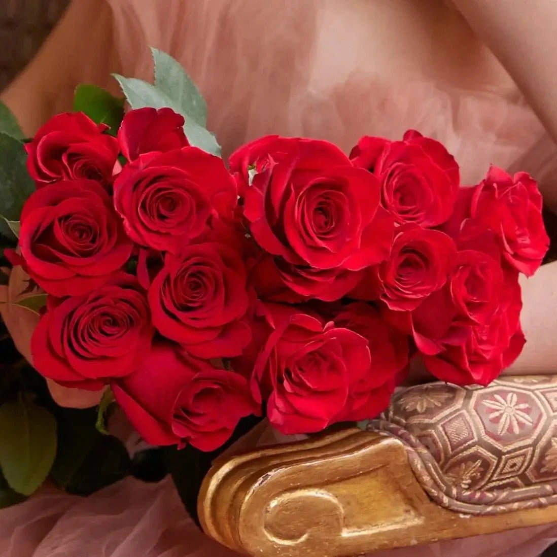 Buquê de rosas vermelhas em caixa de luxo - modelo sentada numa cadeira dourada| QRoses 